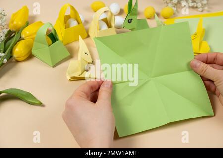 Handicrafts from paper for Easter - origami, making figurines of Easter bunnies, hands close-up Stock Photo