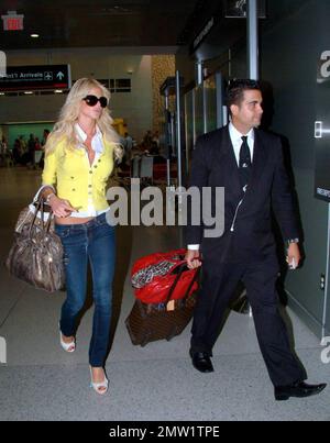 Exclusive!! Playboy Playmate and 1997 Playmate of the Year, Swedish model Victoria Silvstedt arrives at Miami International Airport and is met by her driver. Silvstedt, dressed casually in a yellow sweater, white top and tight-fitting jeans showing off her long legs, was helped to the car with her luggage blowing kisses to the camera along the way. Miami, FL. 4/2/09.   .  . Stock Photo