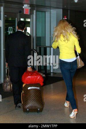 Exclusive!! Playboy Playmate and 1997 Playmate of the Year, Swedish model Victoria Silvstedt arrives at Miami International Airport and is met by her driver. Silvstedt, dressed casually in a yellow sweater, white top and tight-fitting jeans showing off her long legs, was helped to the car with her luggage blowing kisses to the camera along the way. Miami, FL. 4/2/09.   .  . Stock Photo