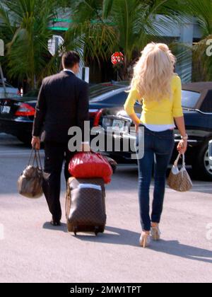 Exclusive!! Playboy Playmate and 1997 Playmate of the Year, Swedish model Victoria Silvstedt arrives at Miami International Airport and is met by her driver. Silvstedt, dressed casually in a yellow sweater, white top and tight-fitting jeans showing off her long legs, was helped to the car with her luggage blowing kisses to the camera along the way. Miami, FL. 4/2/09.   .  . Stock Photo