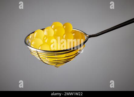 yellow jelly balls for making bubble tea in strainer on grey background Stock Photo