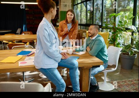 Busy multiracial office employees working in coworking shared room Stock Photo