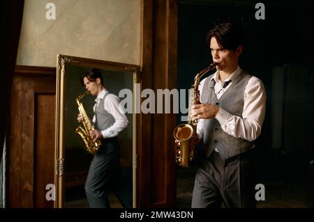 Young man playing saxophone at home Stock Photo