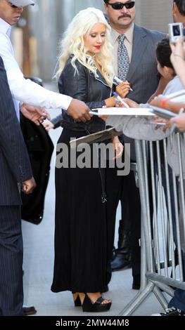 'The Voice' judge Christina Aguilera wears a black leather jacket over a revealing black dress as she signs autographs and greets fans outside the 'Jimmy Kimmel Live' studios. It's reported that Christina is back in the studio working on a new album with producer Scott Storch, who also produced her hits 'Can't Hold Us Down' and 'Fighter.' Los Angeles, CA. 5/26/11. Stock Photo