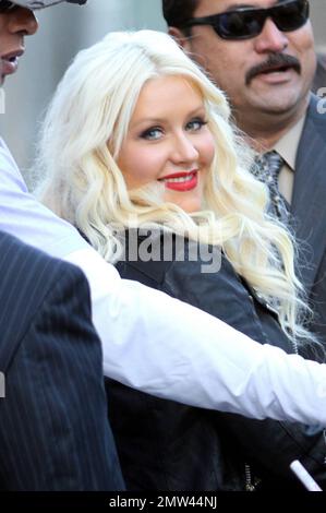 'The Voice' judge Christina Aguilera wears a black leather jacket over a revealing black dress as she signs autographs and greets fans outside the 'Jimmy Kimmel Live' studios. It's reported that Christina is back in the studio working on a new album with producer Scott Storch, who also produced her hits 'Can't Hold Us Down' and 'Fighter.' Los Angeles, CA. 5/26/11. Stock Photo