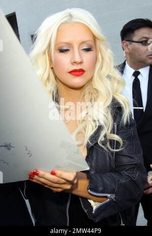 'The Voice' judge Christina Aguilera wears a black leather jacket over a revealing black dress as she signs autographs and greets fans outside the 'Jimmy Kimmel Live' studios. It's reported that Christina is back in the studio working on a new album with producer Scott Storch, who also produced her hits 'Can't Hold Us Down' and 'Fighter.' Los Angeles, CA. 5/26/11. Stock Photo