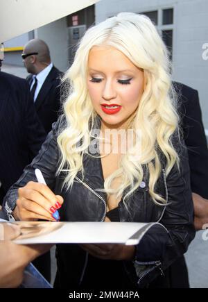 'The Voice' judge Christina Aguilera wears a black leather jacket over a revealing black dress as she signs autographs and greets fans outside the 'Jimmy Kimmel Live' studios. It's reported that Christina is back in the studio working on a new album with producer Scott Storch, who also produced her hits 'Can't Hold Us Down' and 'Fighter.' Los Angeles, CA. 5/26/11. Stock Photo