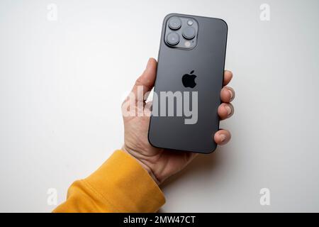 A man holds the latest iPhone 14 Pro Max in Space Black. Apple's latest phone is equipped with three cameras. Stock Photo