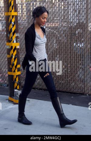 A casually dressed Zoe Saldana signs autographs for fans as she arrives