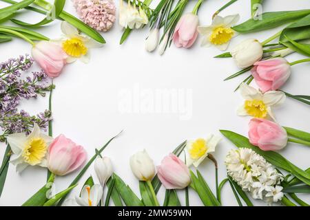 Frame made of spring flowers on white background, top view with space for text Stock Photo