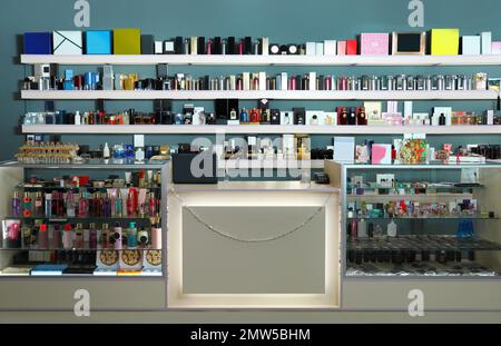 Counter and shelves with perfume bottles in shop Stock Photo
