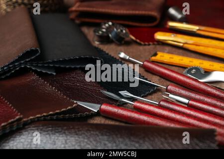 Leather samples and tools on brown table, closeup Stock Photo