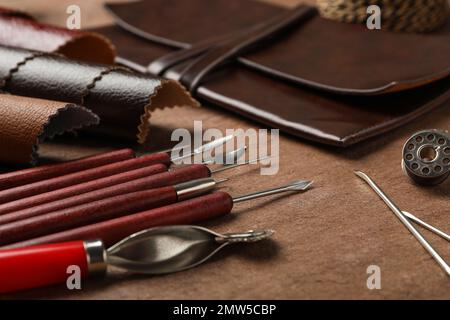 Leather samples and tools on brown table, closeup Stock Photo