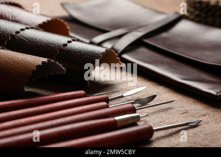 Leather samples and tools on brown table, closeup Stock Photo
