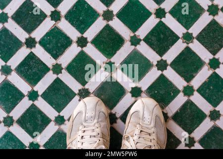 Scenic view of man sport shoes on colored tiles pattern in Marrakesh touristic spot in Morocco Stock Photo