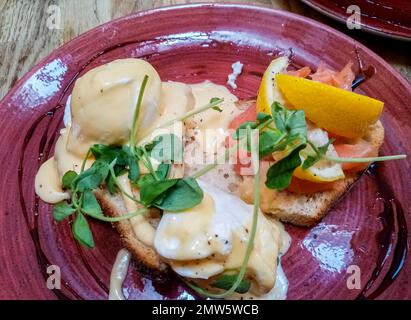 Top view of poached eggs with sauce and salmon on toast. Stock Photo