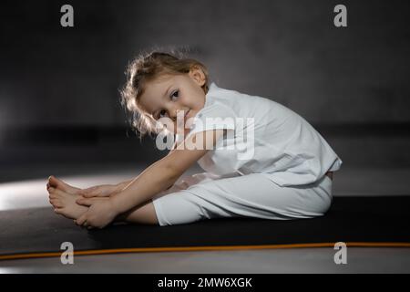 Little cute girl practicing yoga pose, isolated on white :: Stock