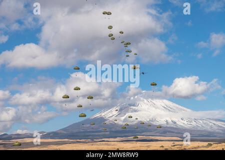 Shizuoka Prefecture, Japan. 31st Jan, 2023. Japan Ground Self-Defense Force paratroopers with the 1st Airborne Brigade descend from a U.S Air Force C-130J Super Hercules aircraft with snowcapped Mount Fuji behind at the East Fuji Maneuver Area, January 31, 2023 in Honshu, Japan. Credit: Yasuo Osakabe/U.S. Air Force/Alamy Live News Stock Photo