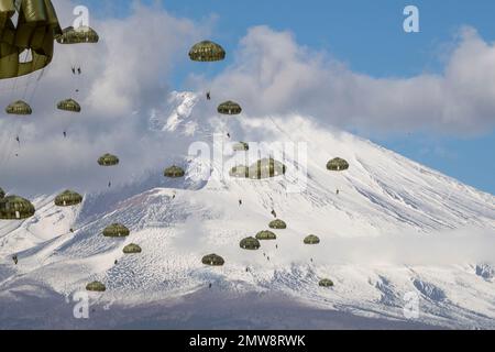 Shizuoka Prefecture, Japan. 31st Jan, 2023. Japan Ground Self-Defense Force paratroopers with the 1st Airborne Brigade descend from a U.S Air Force C-130J Super Hercules aircraft with snowcapped Mount Fuji behind at the East Fuji Maneuver Area, January 31, 2023 in Honshu, Japan. Credit: Yasuo Osakabe/U.S. Air Force/Alamy Live News Stock Photo