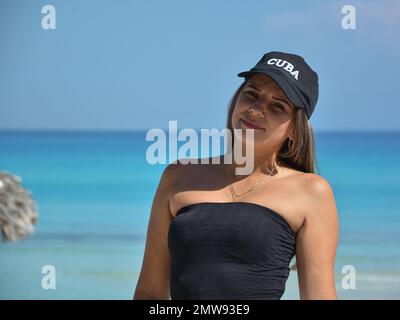 Pretty black woman wearing a swim suit and sitting in a stream as it flows  over dark rock Stock Photo - Alamy