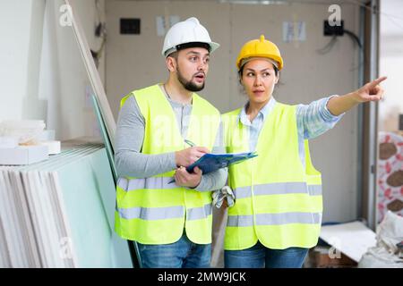Woman and man repairers talking about documentation Stock Photo