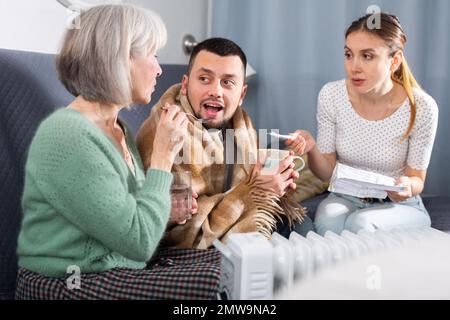 Mother giving medicines to sick adult son Stock Photo