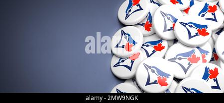 Logos of the American Major League Baseball Team Toronto Blue Jays on a heap on a table. Stock Photo