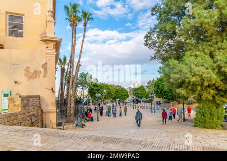 Tourists visit the Kedumim Square with the city of Tel Aviv in the distance at the ancient city of Old Jaffa, Israel Stock Photo