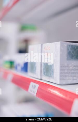 Drugstore shelves stocked with various medicinal products and aloe vera cream ready for clients to come and buy during checkup visit in pharmacy. Medicine support service and concept Stock Photo