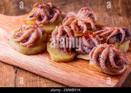 Pulpo a la Gallega (Galician-style octopus) is a typical dish from Galicia. Octopus on the cutting board. Stock Photo