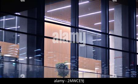 Skyscraper lobby in  business district. Big glass windows in commercial skyscraper at night. Stock Photo