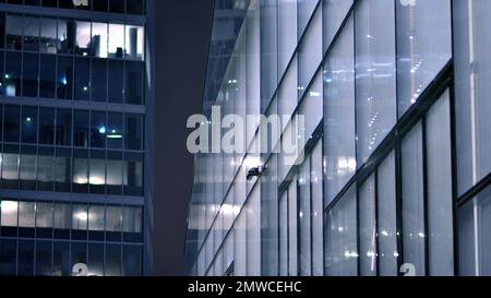 Skyscraper lobby in  business district. Big glass windows in commercial skyscraper at night. Stock Photo