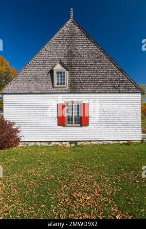 Side view of old white with tan trim 1752 French regime cottage style home in autumn, Saint-Francois, Ile d'Orleans, Quebec, Canada. Stock Photo