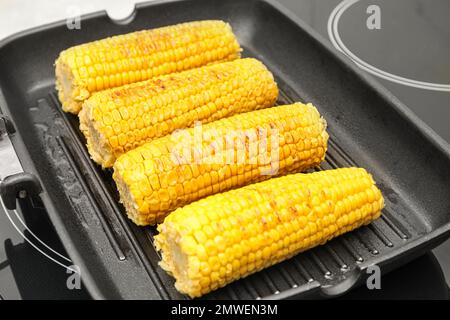 Fresh corn cobs on grill pan, closeup Stock Photo