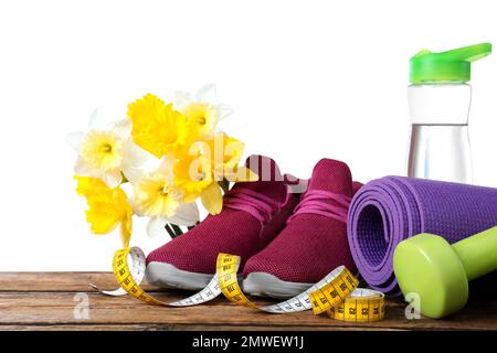 Composition with spring flowers and sports items on wooden table against white background Stock Photo