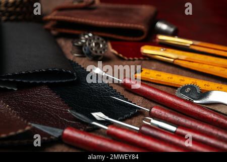 Leather samples and tools on brown table, closeup Stock Photo