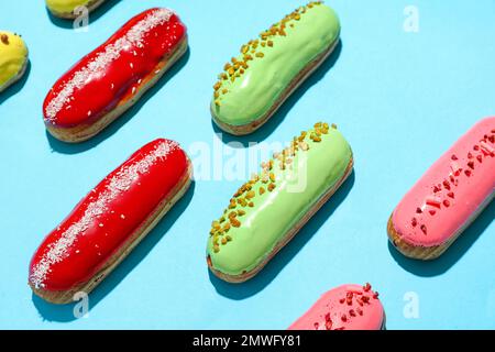 Composition with delicious eclairs on blue background Stock Photo