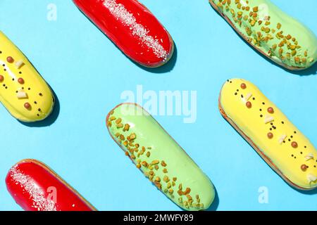 Composition with delicious eclairs on blue background Stock Photo