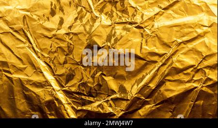 Bright yellow texture of crumpled and creased gold foil or leaf for background. Stock Photo