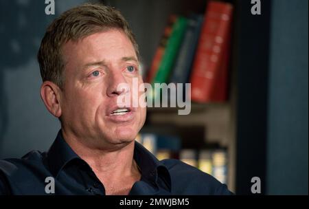 Troy Aikman, left, and Daryl Moose Johnston sign footballs for