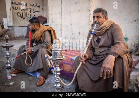 Egyptian men smoking shisha with hookahs in the streets of Luxor, Egypt Stock Photo