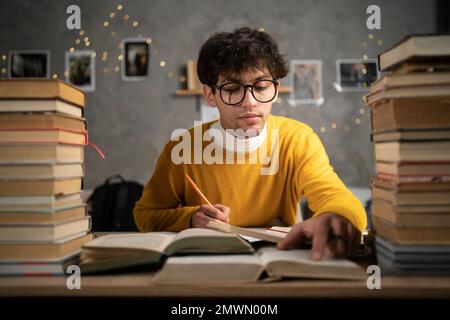 Student preparing for university exams at dormitory in the evening. Copy space Stock Photo