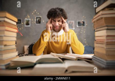 Serious man student focused thinking in library silence prepare for college exams. Copy space Stock Photo