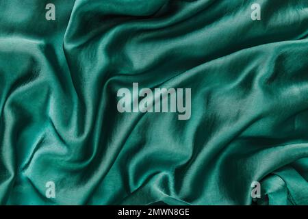 Green silk or satin texture close-up, fabric background Stock Photo