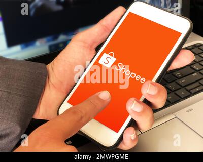 Shopee is e-commerce technology company. Smartphone with Shopee logo on the  screen, shopping cart and parcels Stock Photo - Alamy