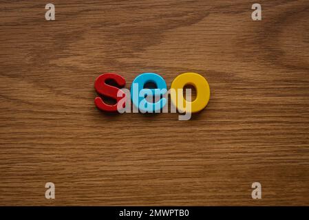 Search engine optimization concept. Alphabet of seo on a wooden background. Stock Photo