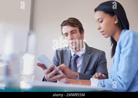 Discussing digital strategies. two business colleagues talking at a table over a digital tablet. Stock Photo