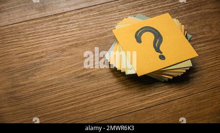 Questions and answers concept. A stack of paper with a paper on top written with question symbol. Stock Photo