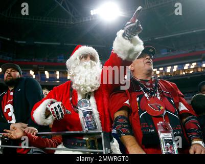 An Arizona Cardinals fan, dressed as Santa Claus, cheers during the first  half of an NFL football game against the Indianapolis Colts, Saturday, Dec.  25, 2021, in Glendale, Ariz. (AP Photo/Rick Scuteri