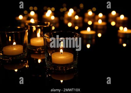 Burning candles in glass holders on table Stock Photo